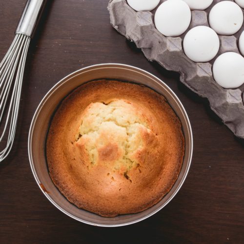 baked muffins beside tray of eggs and whisker