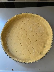 Moule foncé avec la pâte sucrée, on voit quelques rustines parce que j’ai deux mains gauches. Pâte dûment piquée à la fourchette