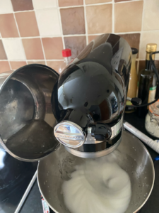 Sirop de sucre versé sur les blancs dans la cuve du batteur