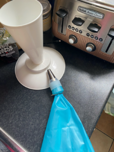 J’ai pris l’habitude de bloquer la sortie de la poche à douille avec une épingle à cheveux pour éviter que l’appareil ne s’écoule par la douille pendant que je remplis la poche. La meringue est épaisse donc aucun risque que ça arrive, donc on calera ceci dans la catégorie trucs & astuces